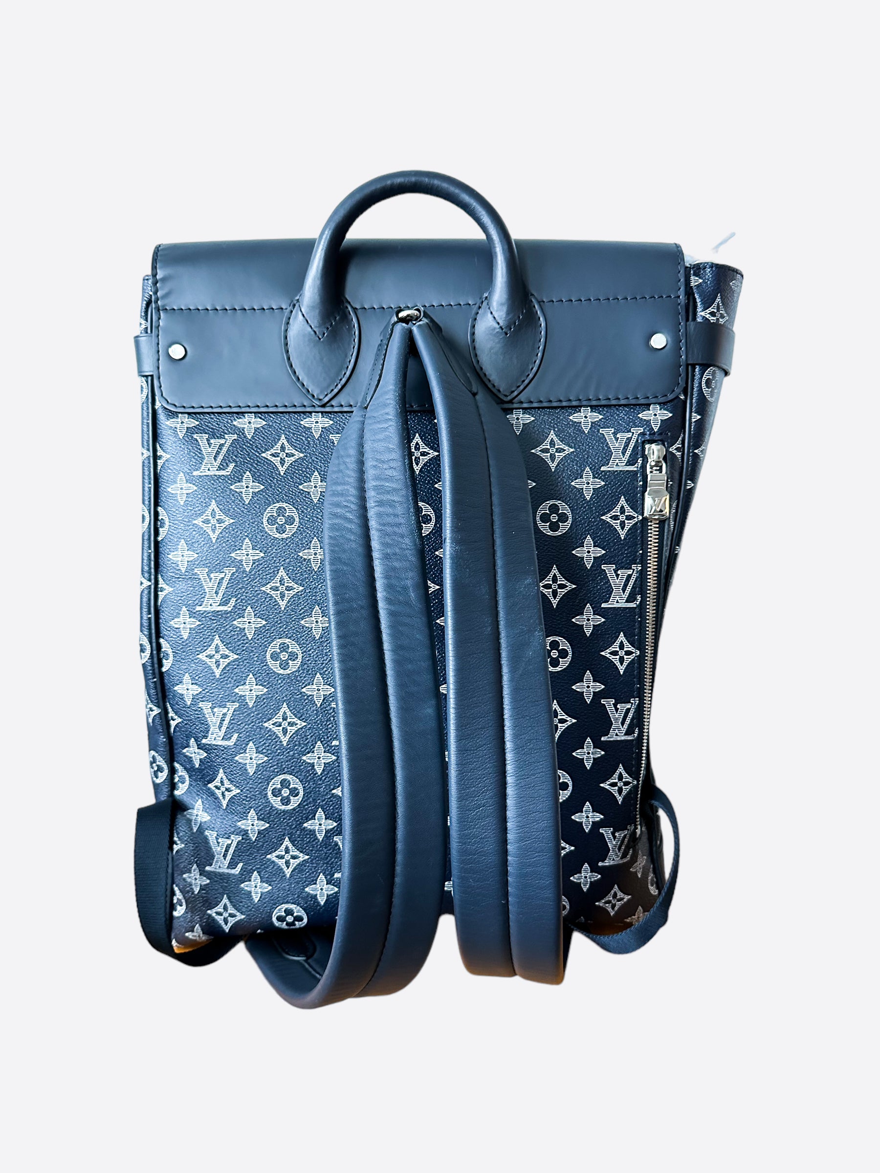 Man with blue leather Louis Vuitton backpack with elephant before